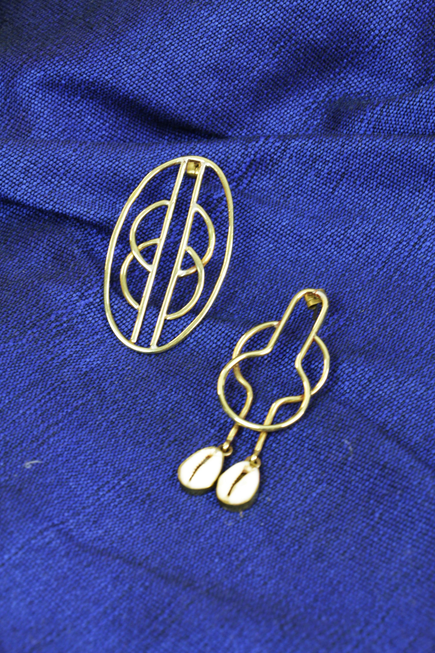 Boucles d'oreilles Kyassa  sur un tissu bleu.